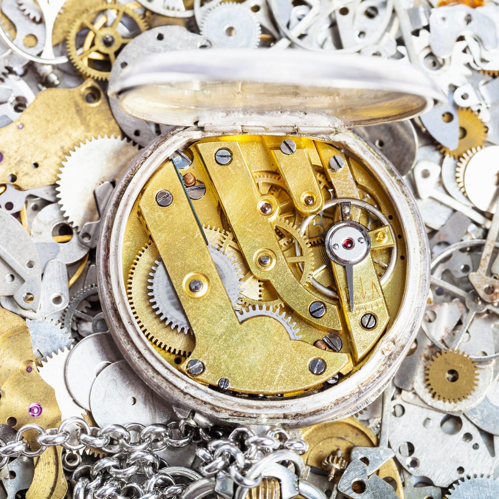Molla di carica e bariletto di un orologio smontati su un panno da lavoro per la revisione